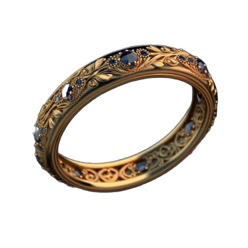 Gold ring with blue gemstones on a white background