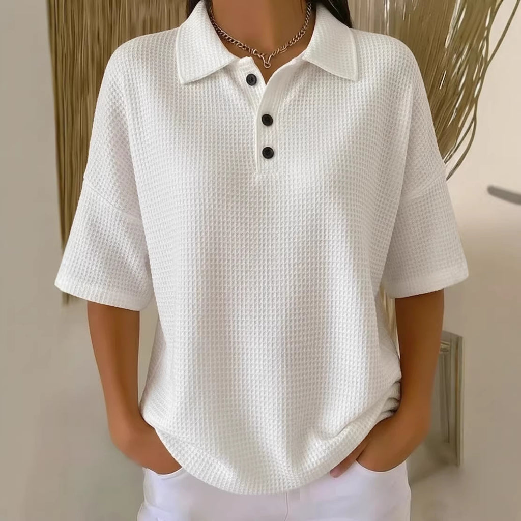White textured polo shirt worn by a person with a neutral background
