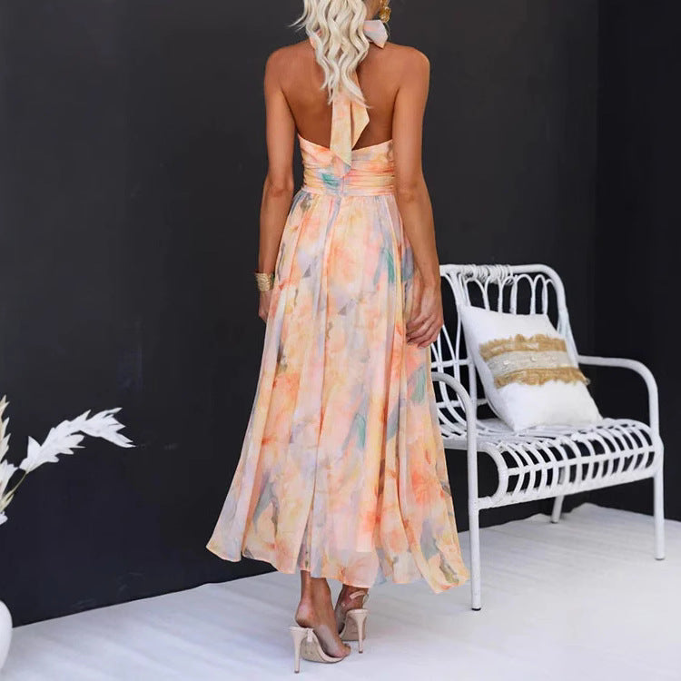 Woman in a colorful dress standing in front of a white chair with a black background