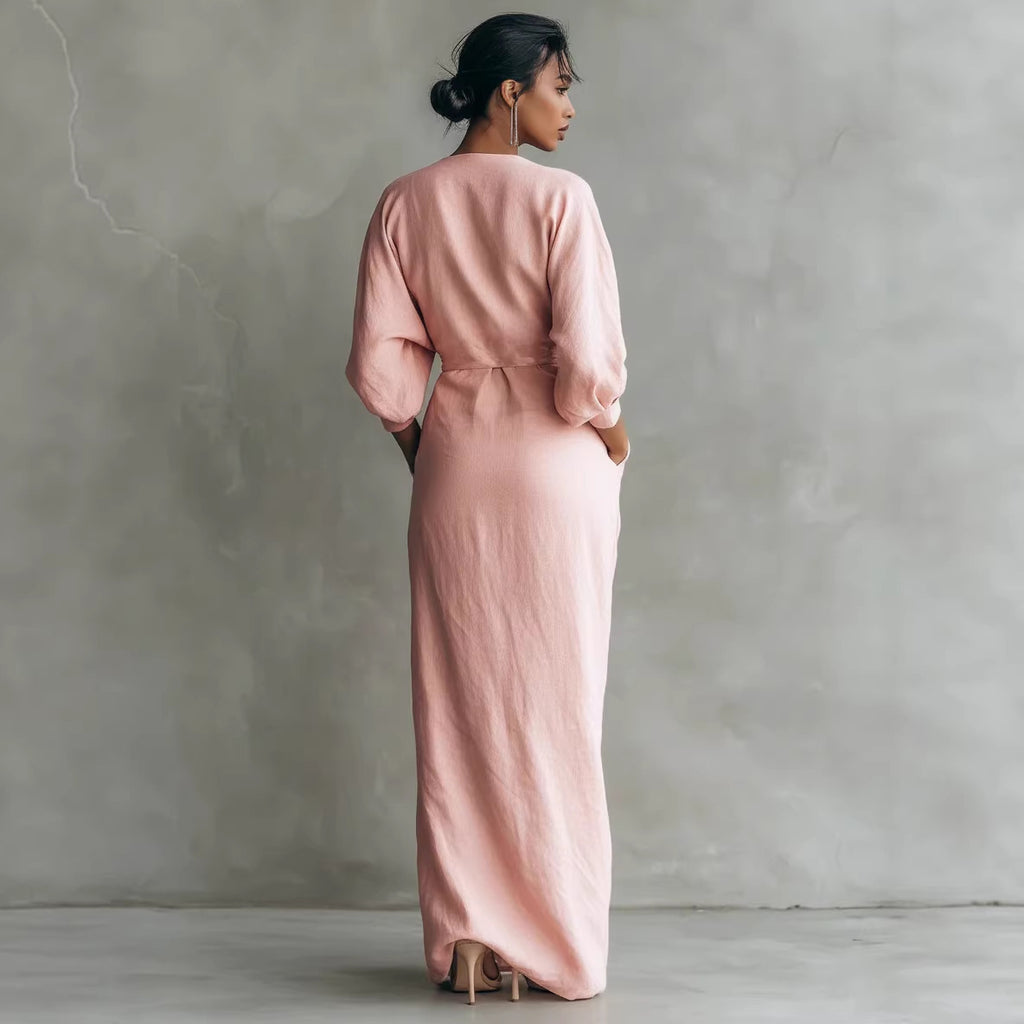 Woman wearing a long pink dress against a plain background