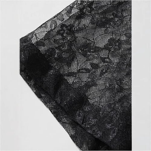 Close-up of black lace fabric on a light gray background