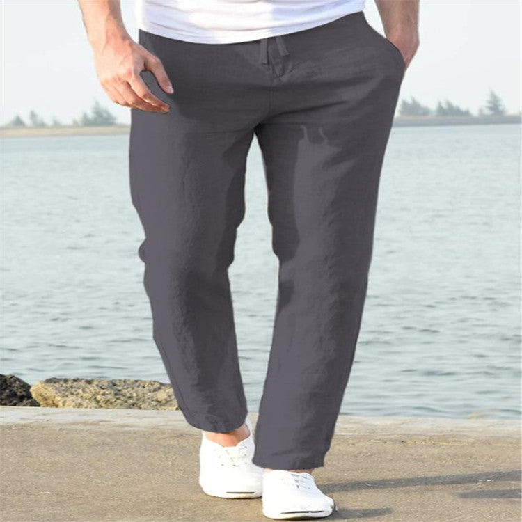 Person wearing gray pants standing by a body of water.