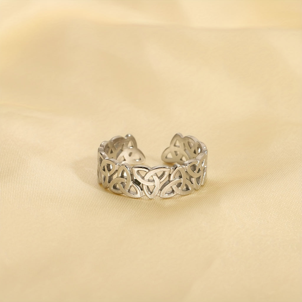 Silver Celtic knot ring on a beige fabric background