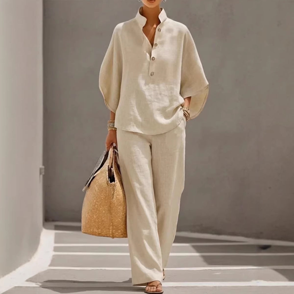 Person wearing a beige outfit holding a woven bag against a neutral background