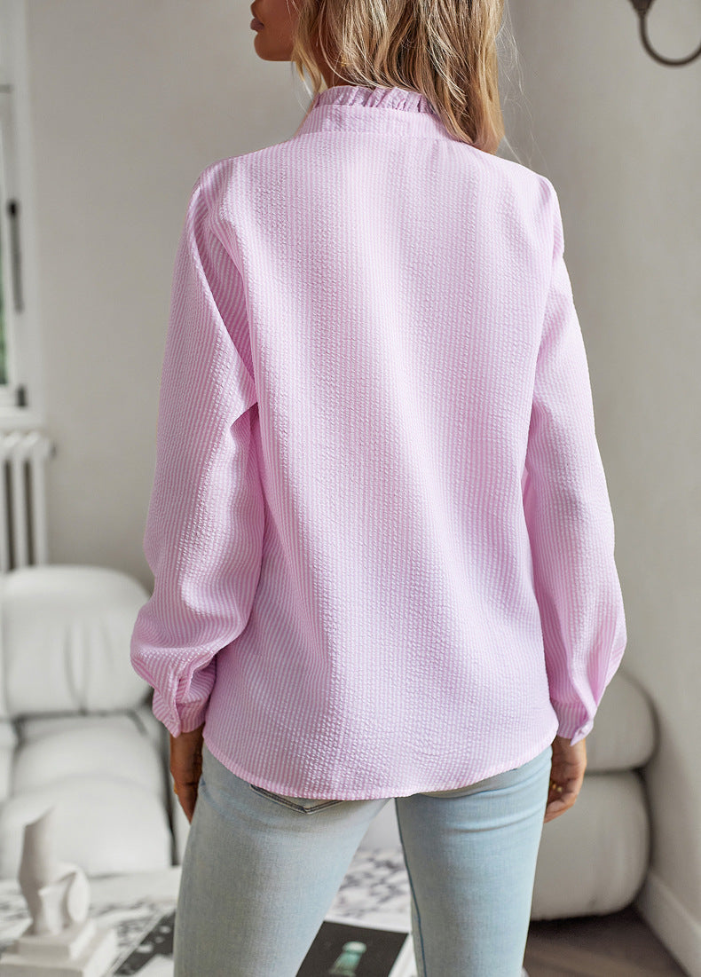 Person wearing a light pink textured shirt in a room with neutral decor