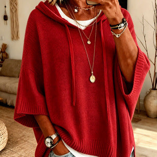 Person wearing a red sweater with a blurred background