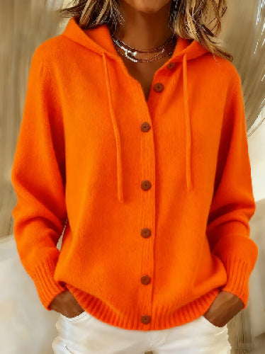 Orange cardigan worn by a person with a neutral background