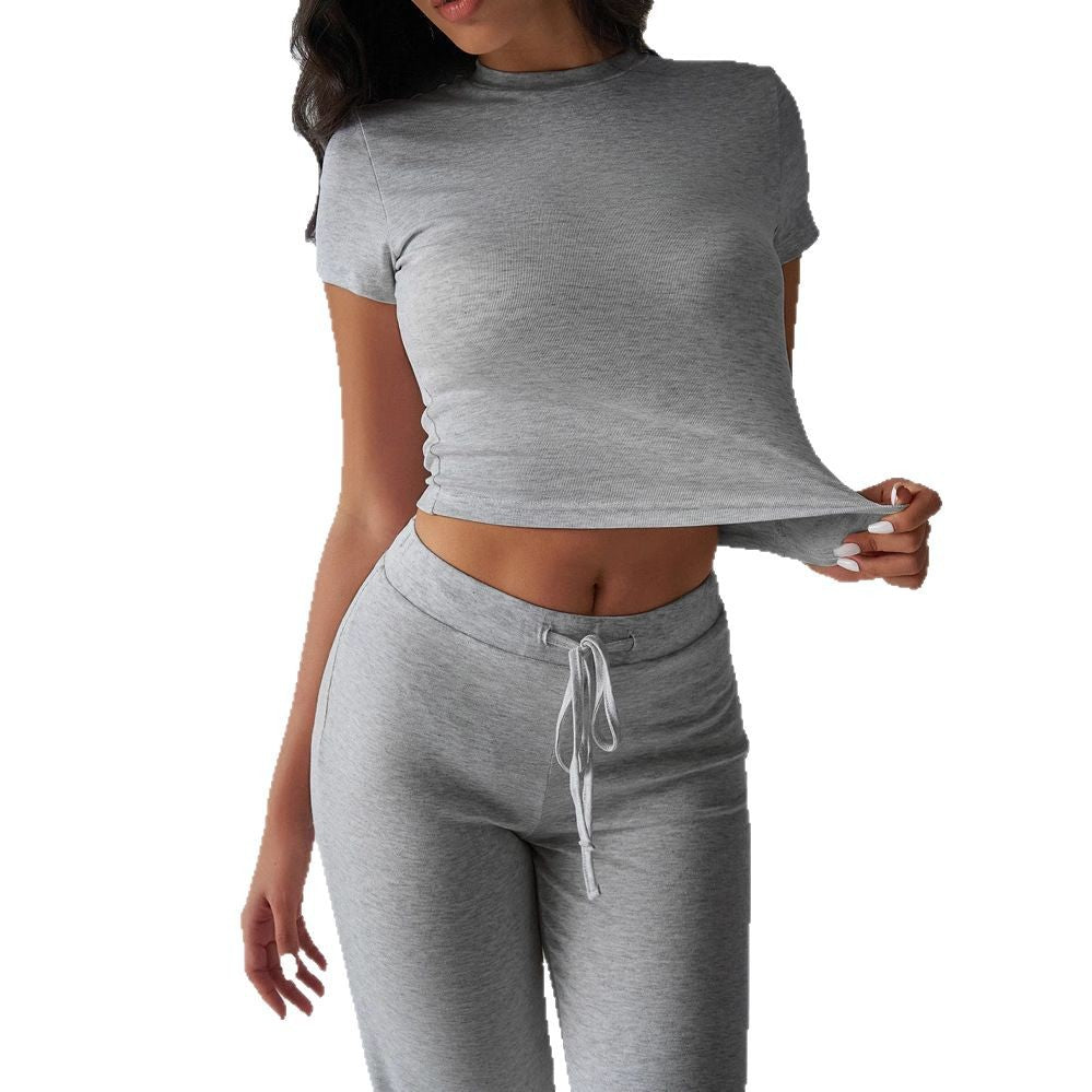 Woman wearing a gray athletic outfit on a white background