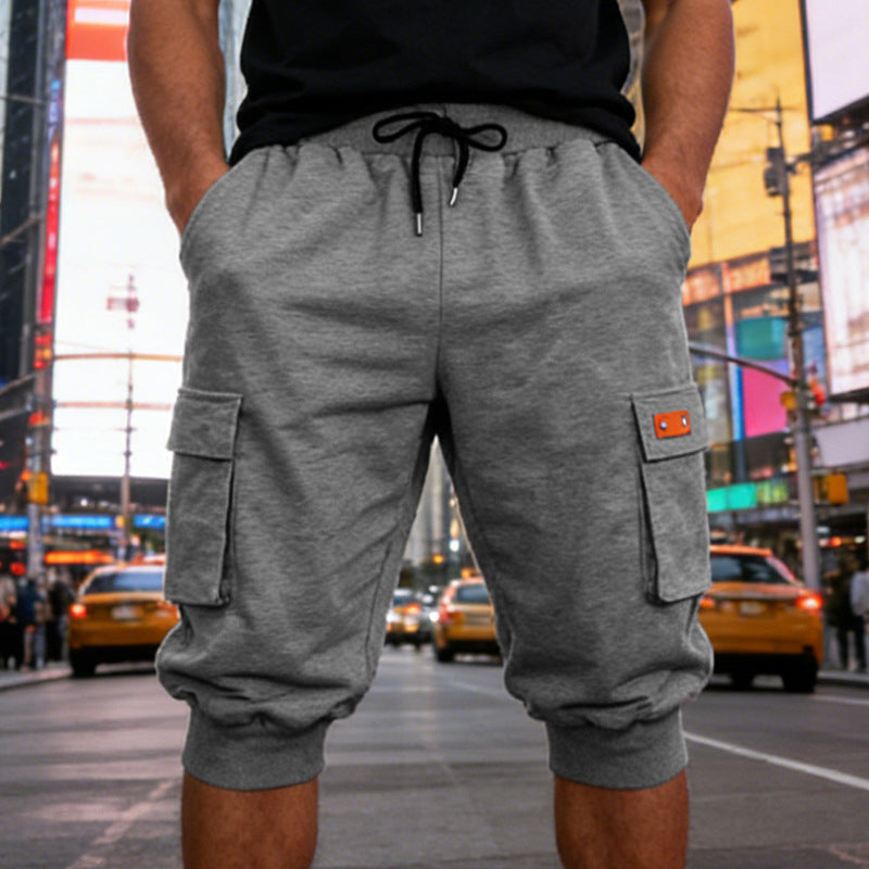Person wearing gray cargo shorts on a city street with colorful billboards in the background