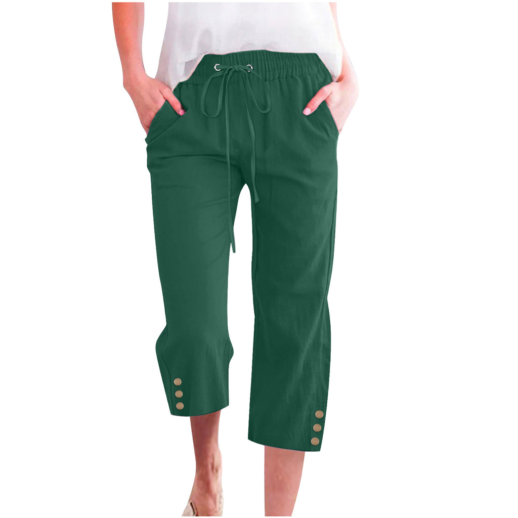 Green capri pants with button details on a white background