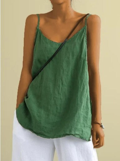 Person wearing a green sleeveless top and white pants against a beige background