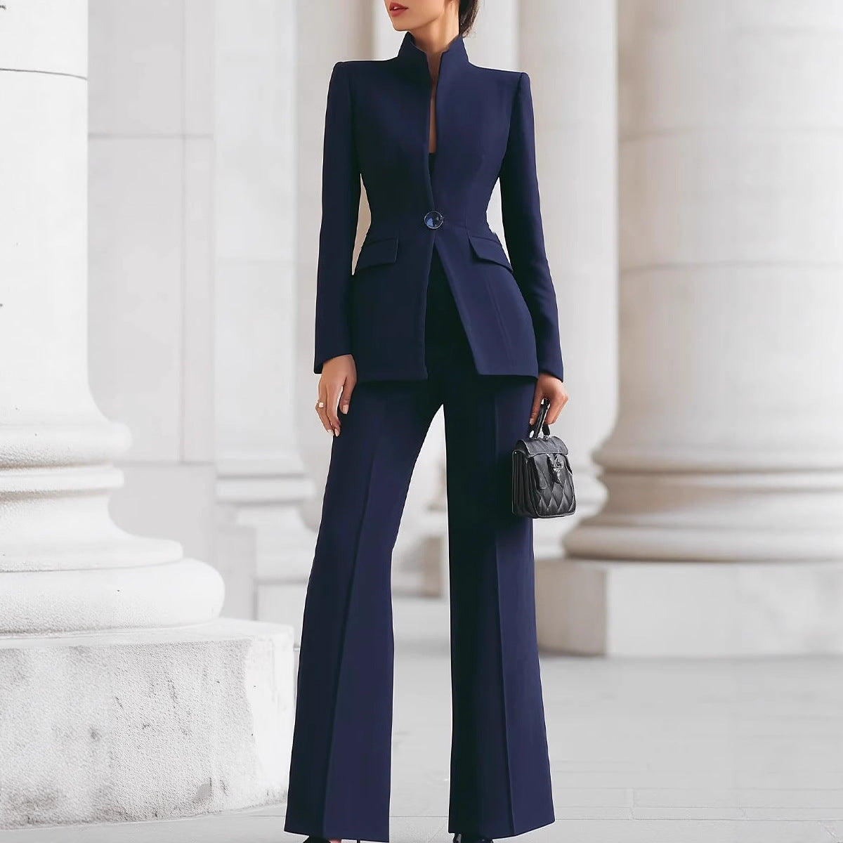 Person wearing a navy blue suit standing in front of classical architecture.