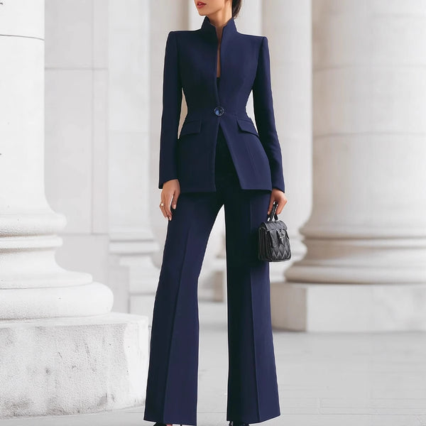 Person wearing a navy blue suit standing in front of classical architecture.