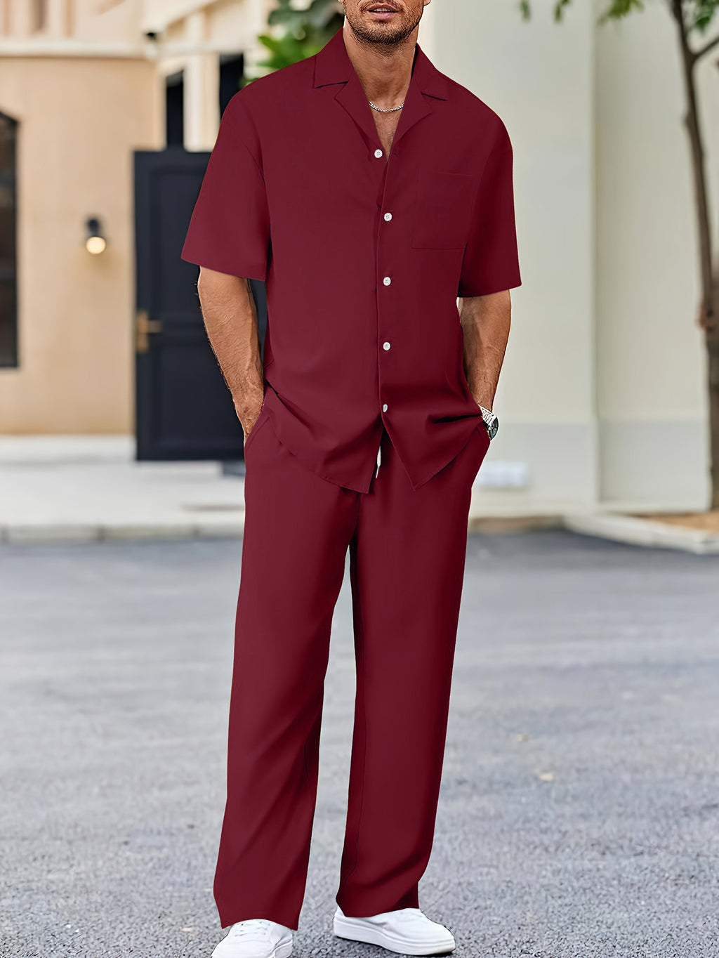 Man wearing a maroon outfit standing outdoors.