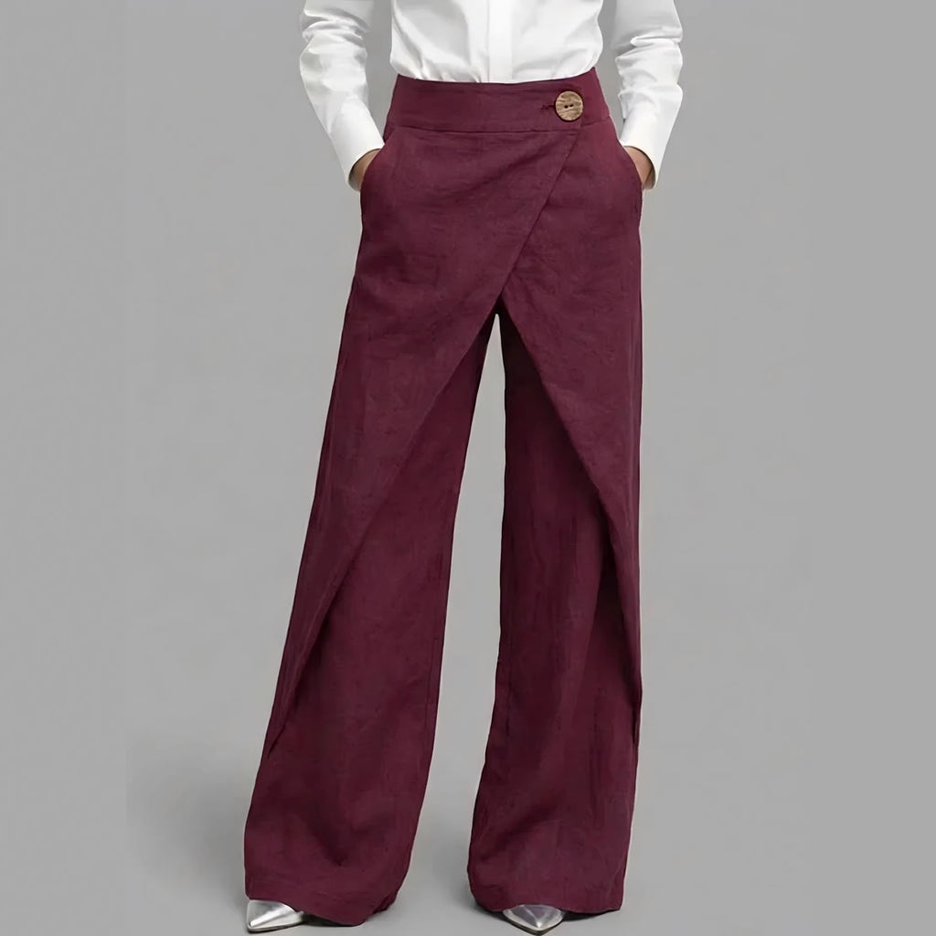 Maroon wide-leg pants worn with a white shirt on a gray background