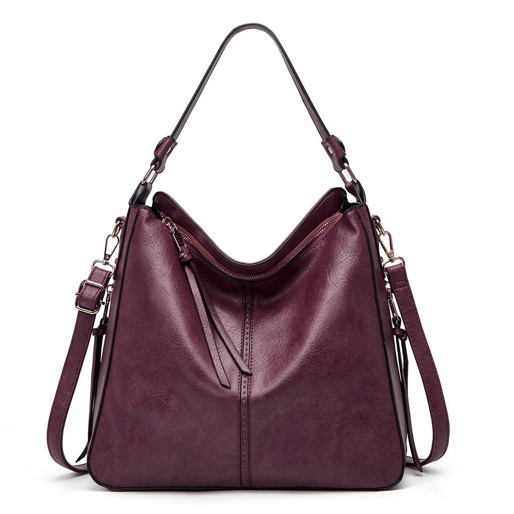 Purple handbag with multiple straps on a white background