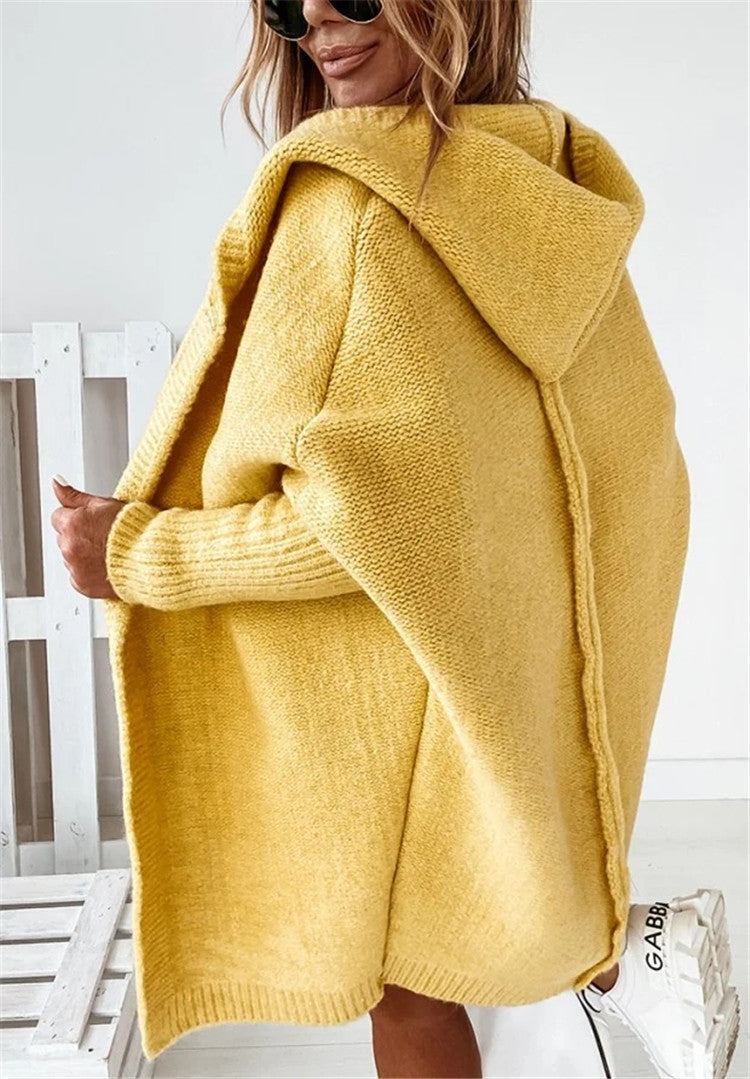 Person wearing a yellow knitted hoodie with a white background