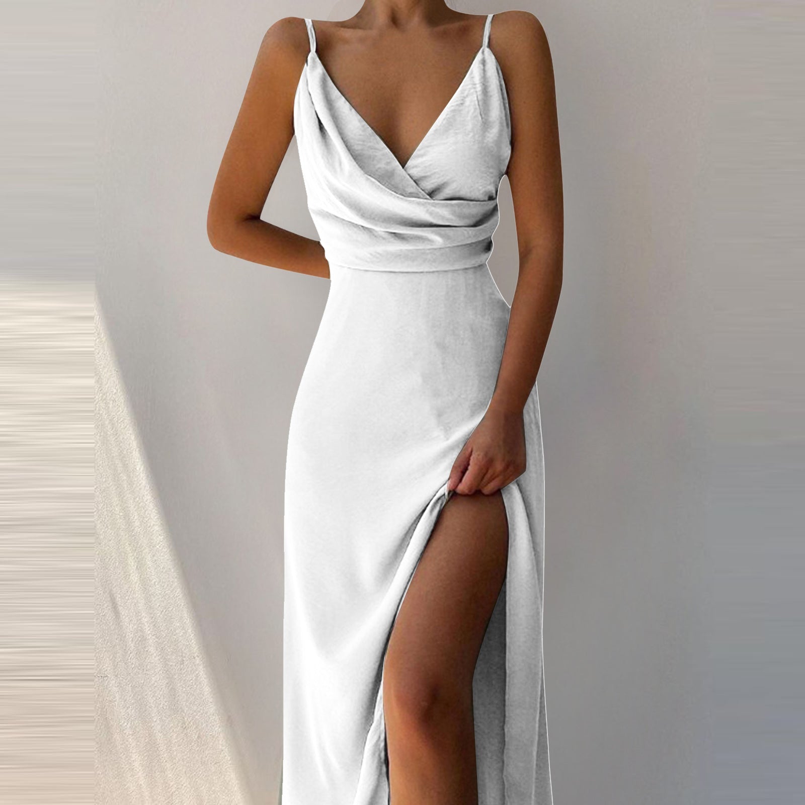 White evening gown with a deep neckline and slit on a neutral background
