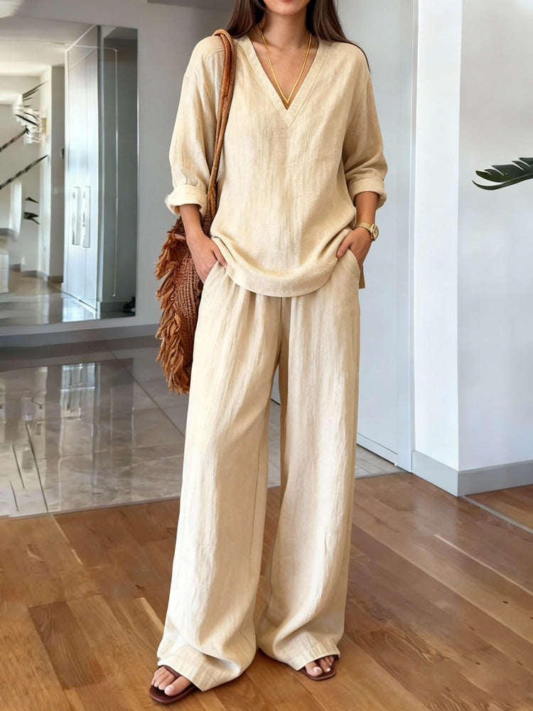 Woman wearing a beige outfit with wide-leg pants in an indoor setting.