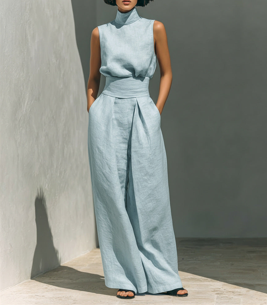 Person wearing a light blue sleeveless top and wide-leg pants against a neutral background