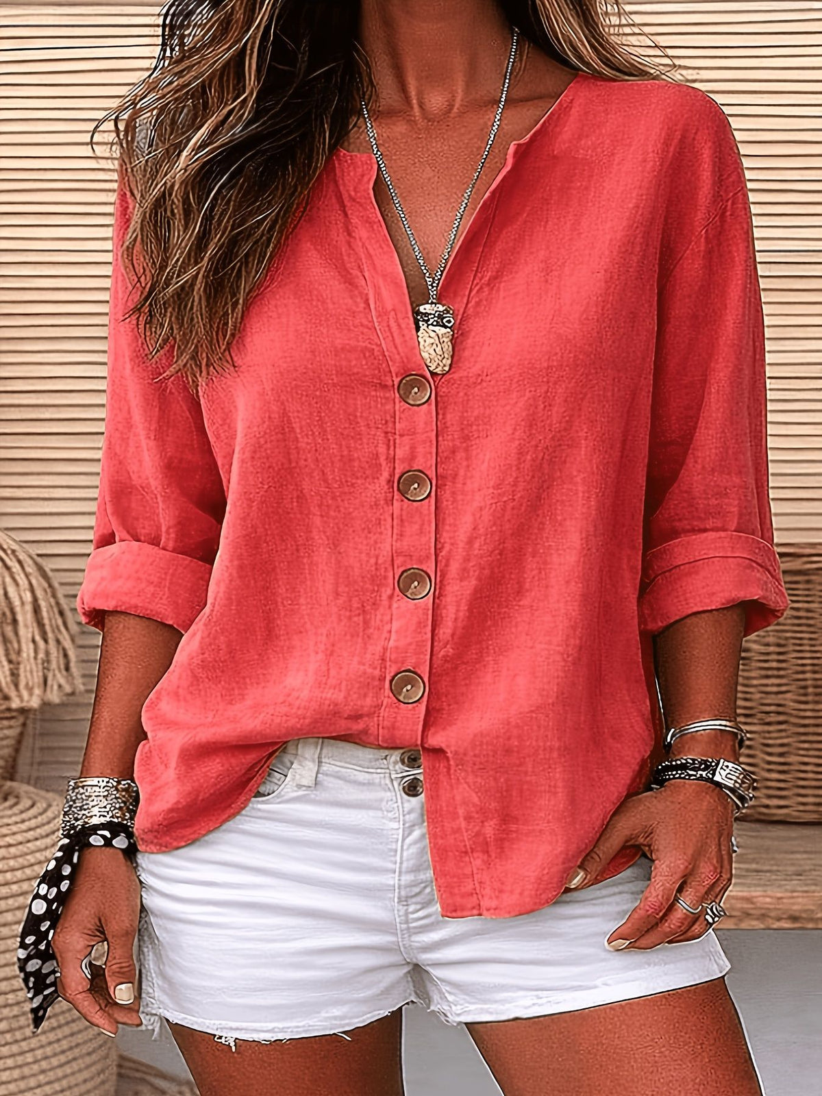 Person wearing a coral button-up shirt and white shorts with a neutral background