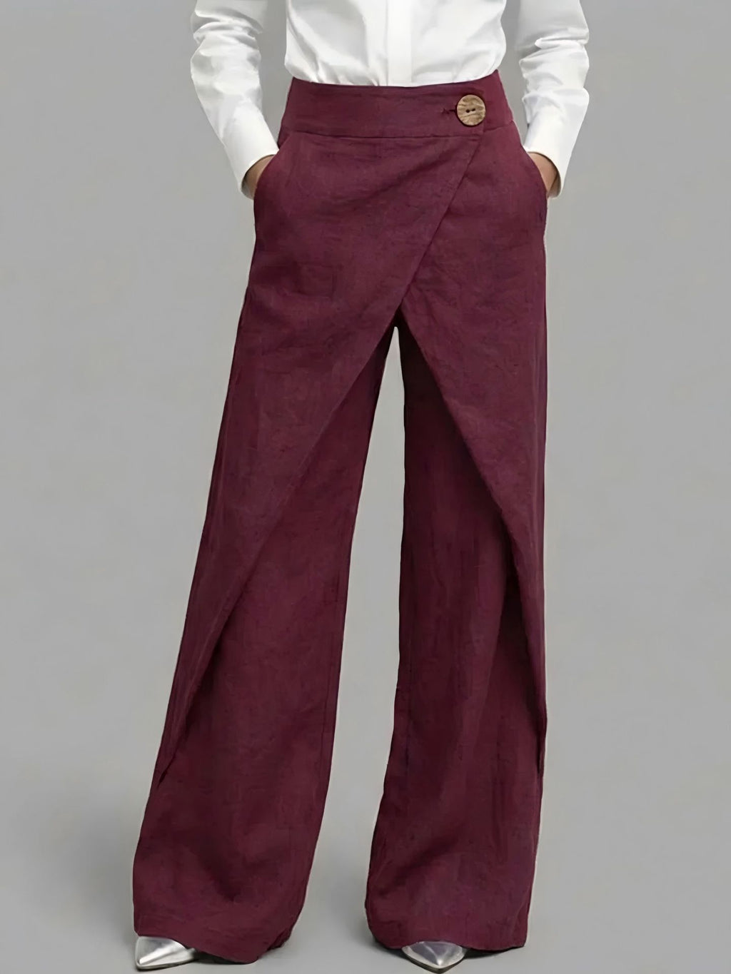 Maroon wide-leg pants worn with a white shirt on a gray background