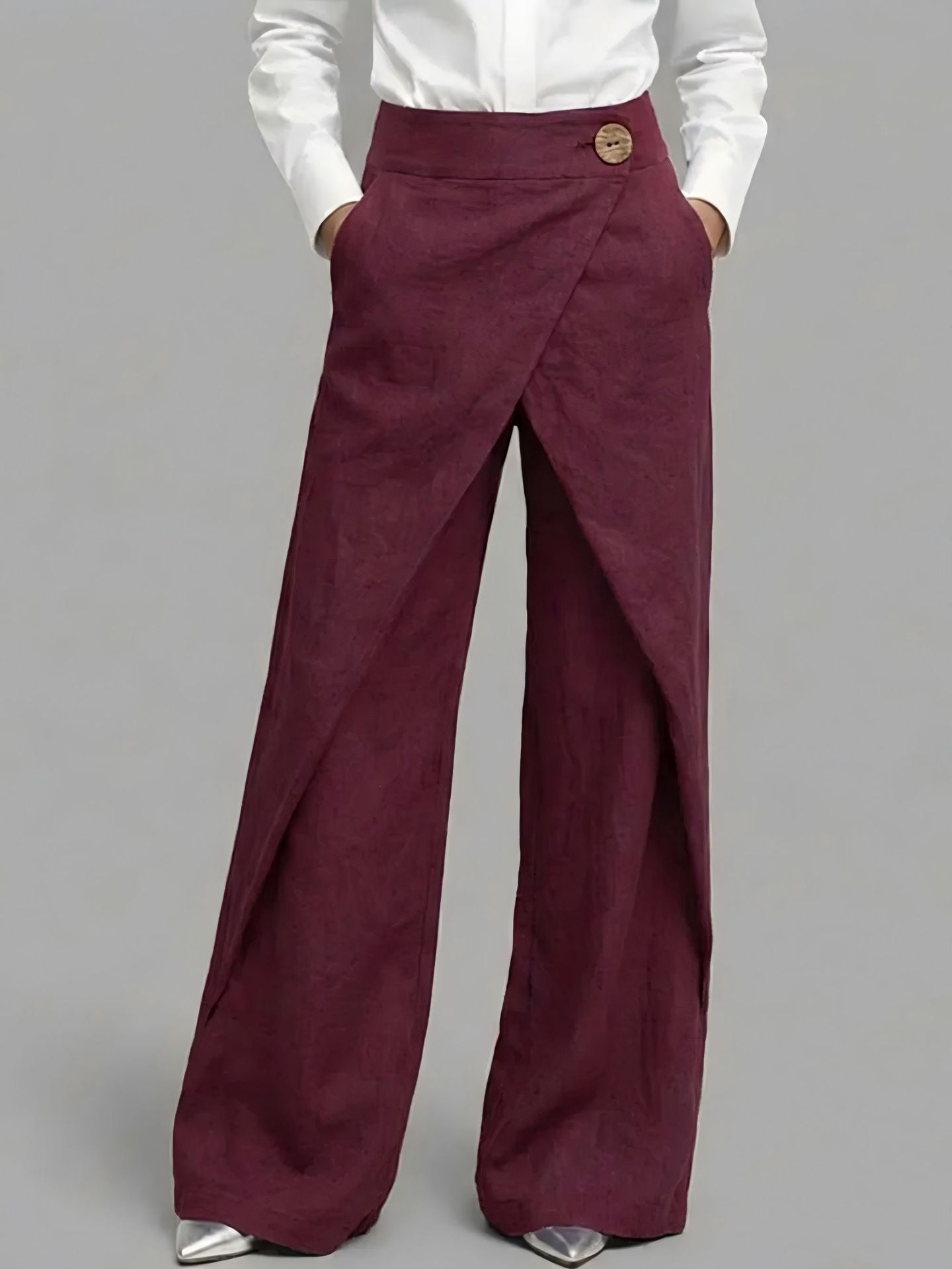 Maroon wide-leg pants worn with a white shirt on a gray background