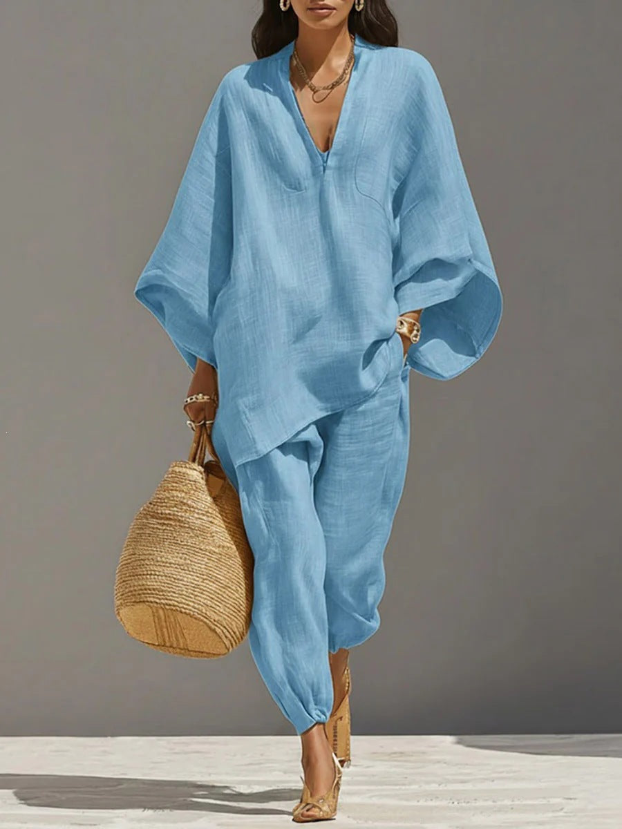 Woman wearing a blue outfit holding a woven bag against a gray background