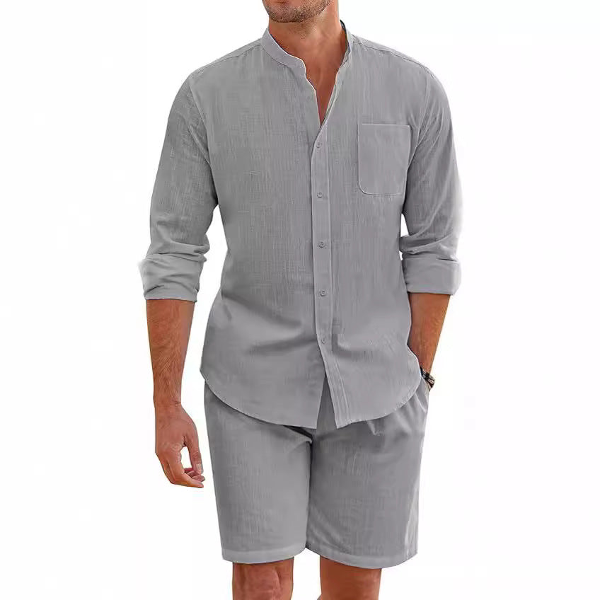 Man wearing a gray button-up shirt and shorts set on a white background