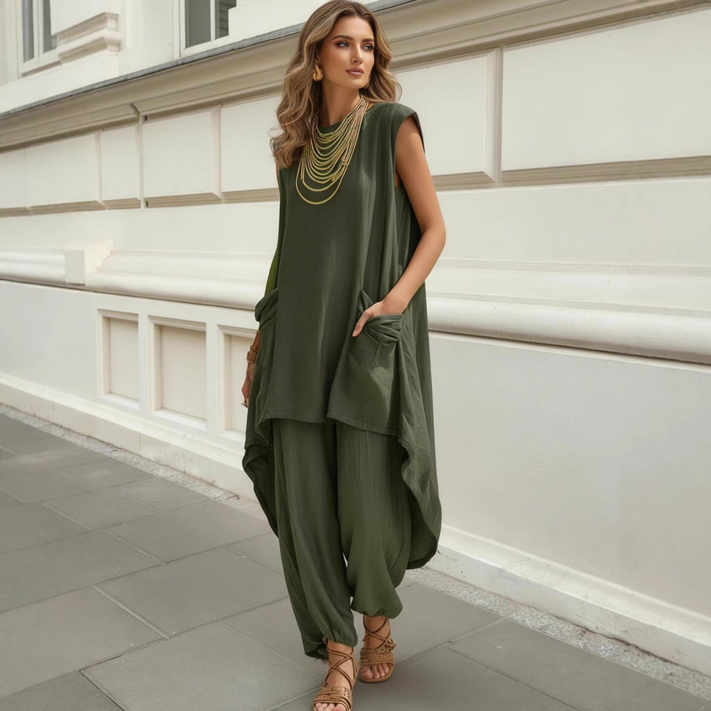 Woman wearing a green outfit standing against a white wall.