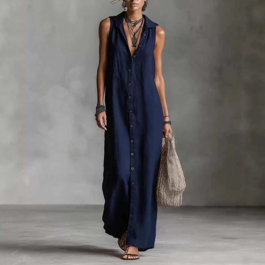Woman wearing a long navy dress against a gray background