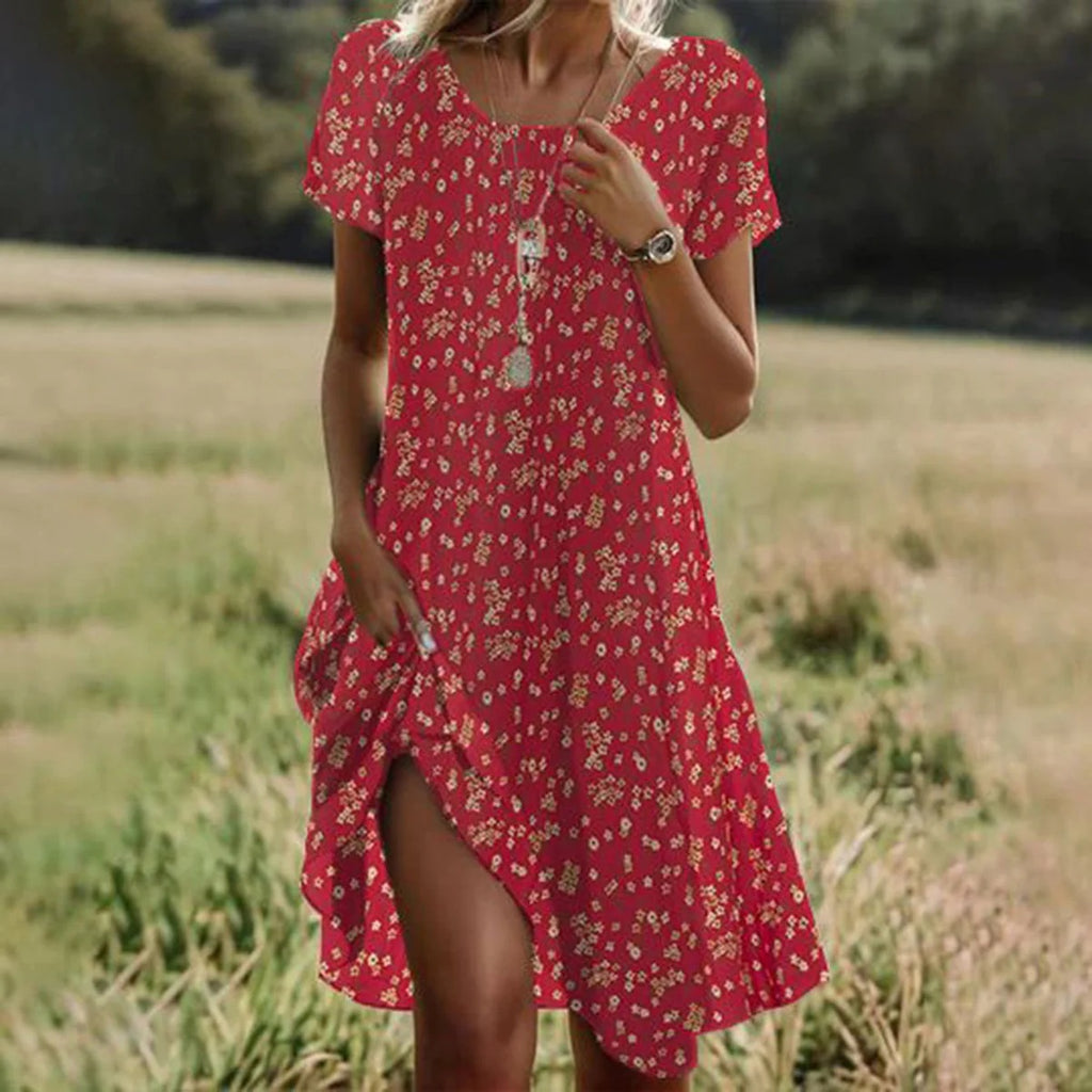 Woman wearing a red floral dress standing in a field