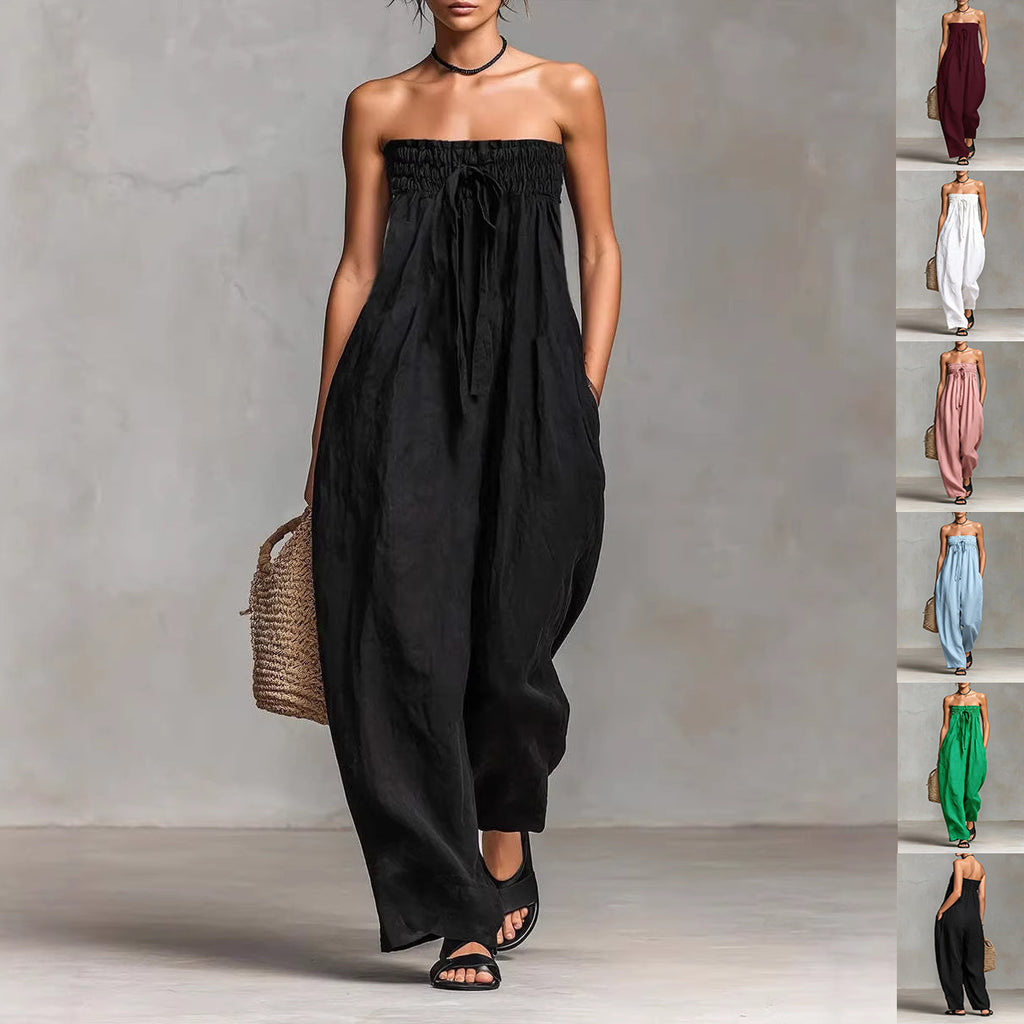 Woman wearing a black strapless jumpsuit against a gray background with a side view of the outfit.