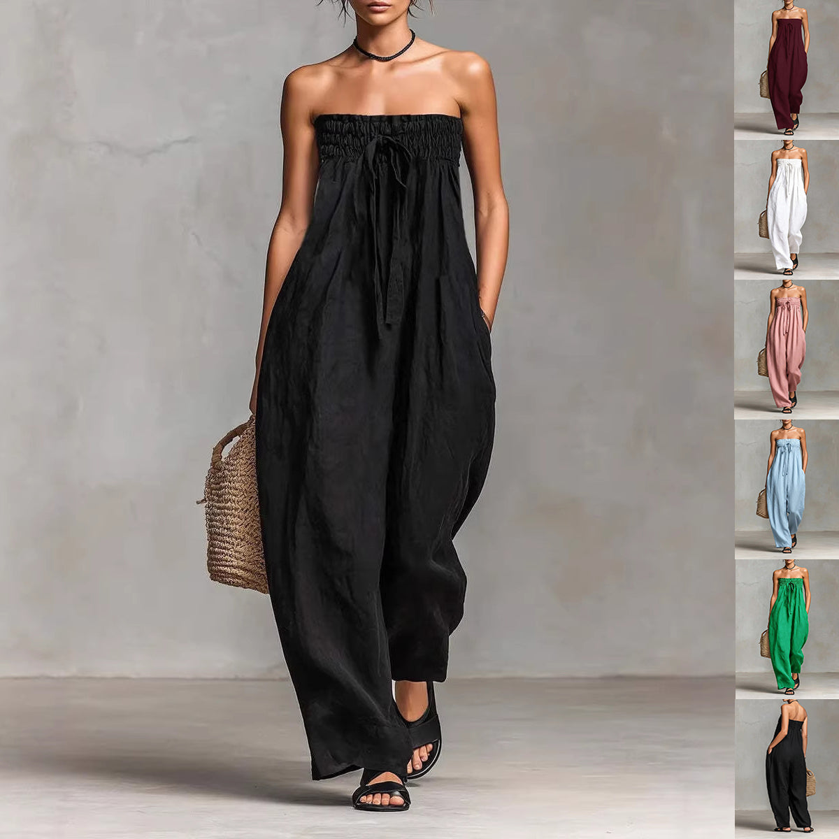 Woman wearing a black strapless jumpsuit against a gray background with a side view of the outfit.