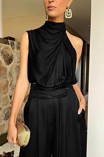 Woman wearing elegant black one-shoulder jumpsuit, gold clutch, and statement earrings, ZA-Zola fashion.