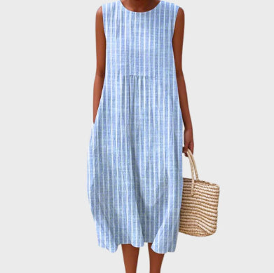 Woman wearing a blue checkered dress holding a woven bag on a white background