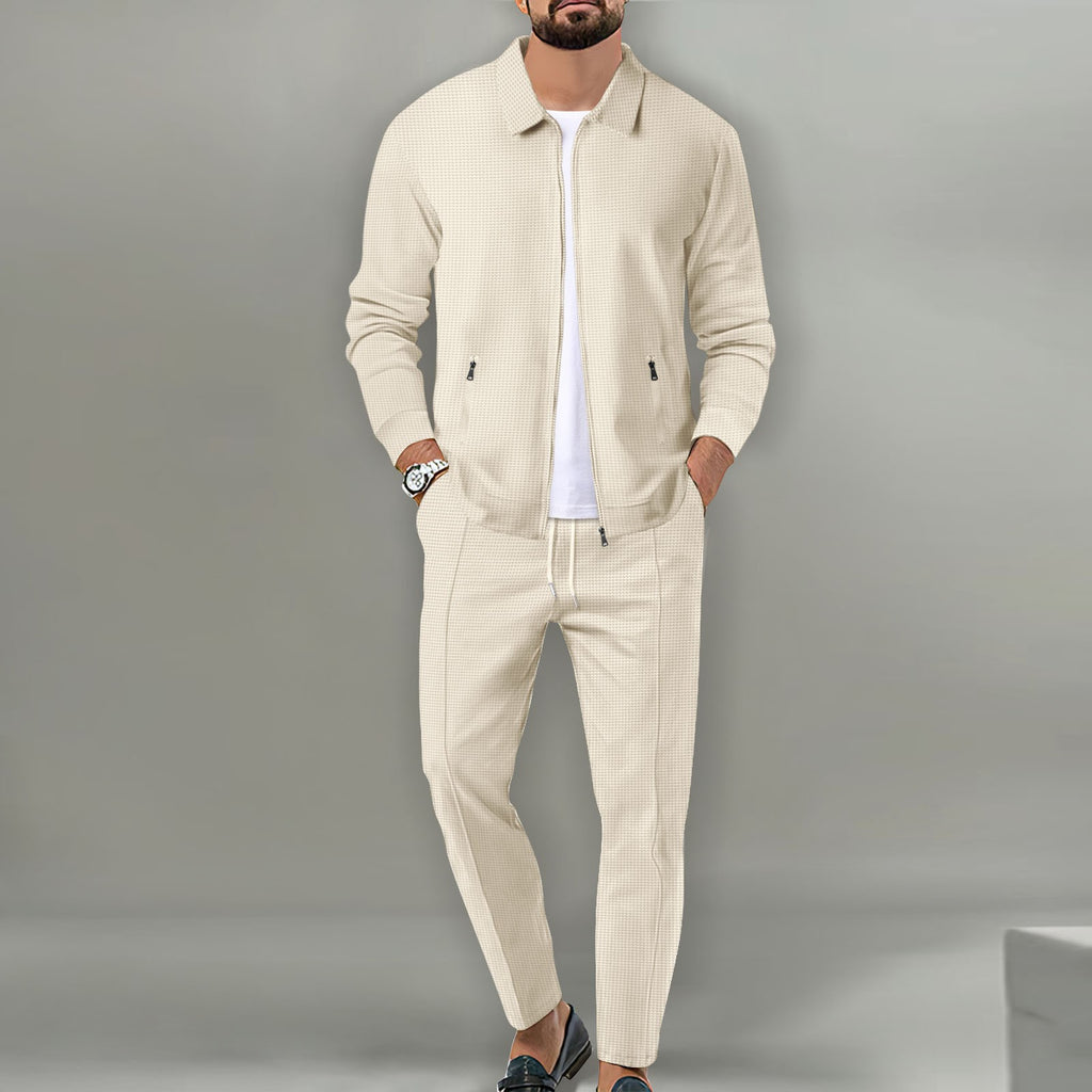 Man wearing a beige tracksuit against a gray background
