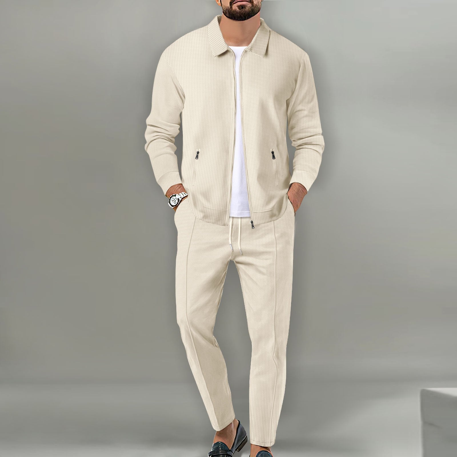 Man wearing a beige tracksuit against a gray background