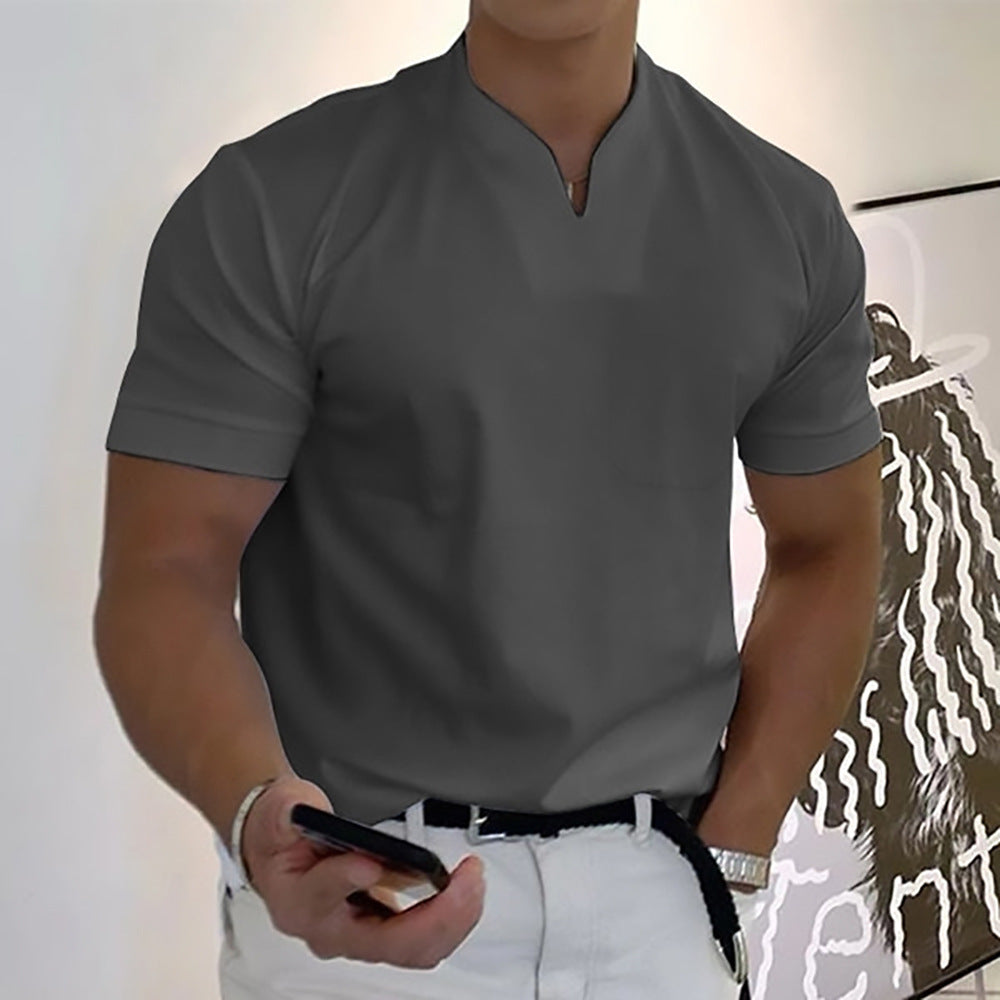 Person wearing a gray t-shirt and white pants, holding a phone.