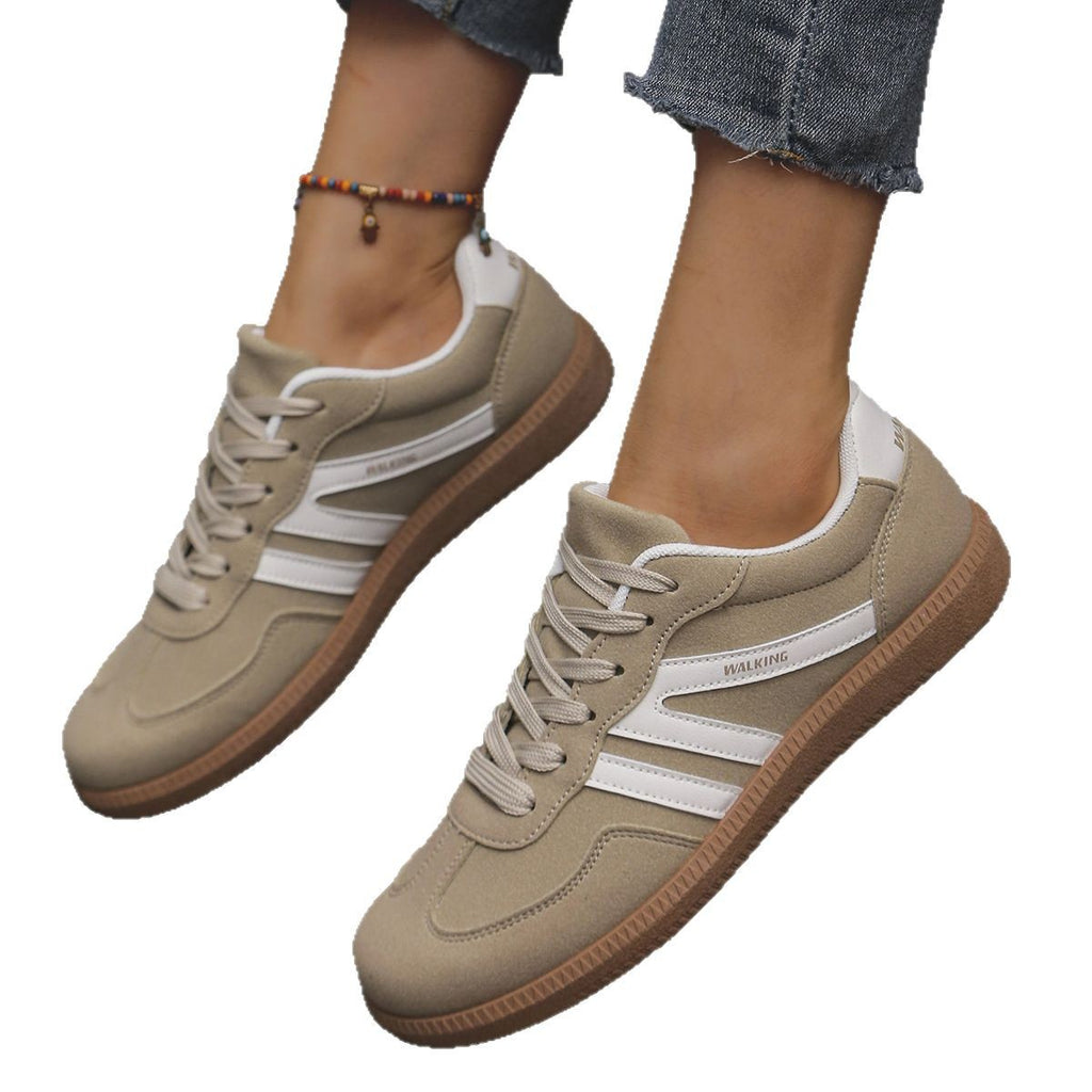 Beige sneakers with white stripes worn by a person on a white background
