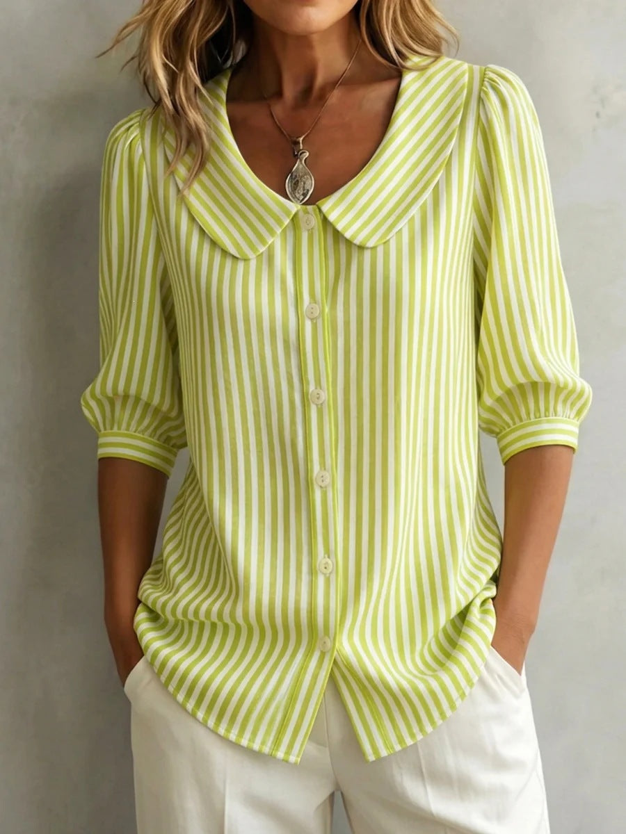Woman wearing a green and white striped blouse against a neutral background