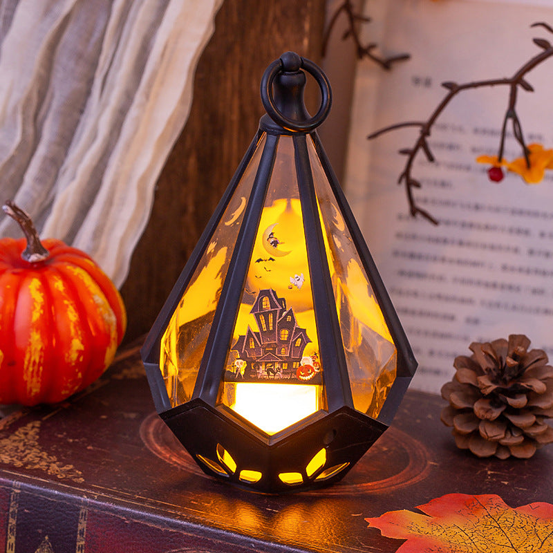 Decorative lantern with haunted house design on a surface with pumpkins and leaves.