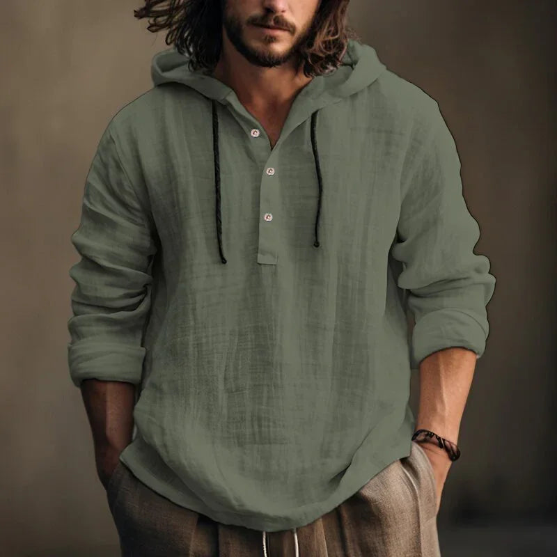 Man wearing a green hooded shirt against a brown background