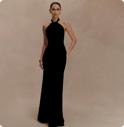 Woman wearing a black halter neck gown against a beige background