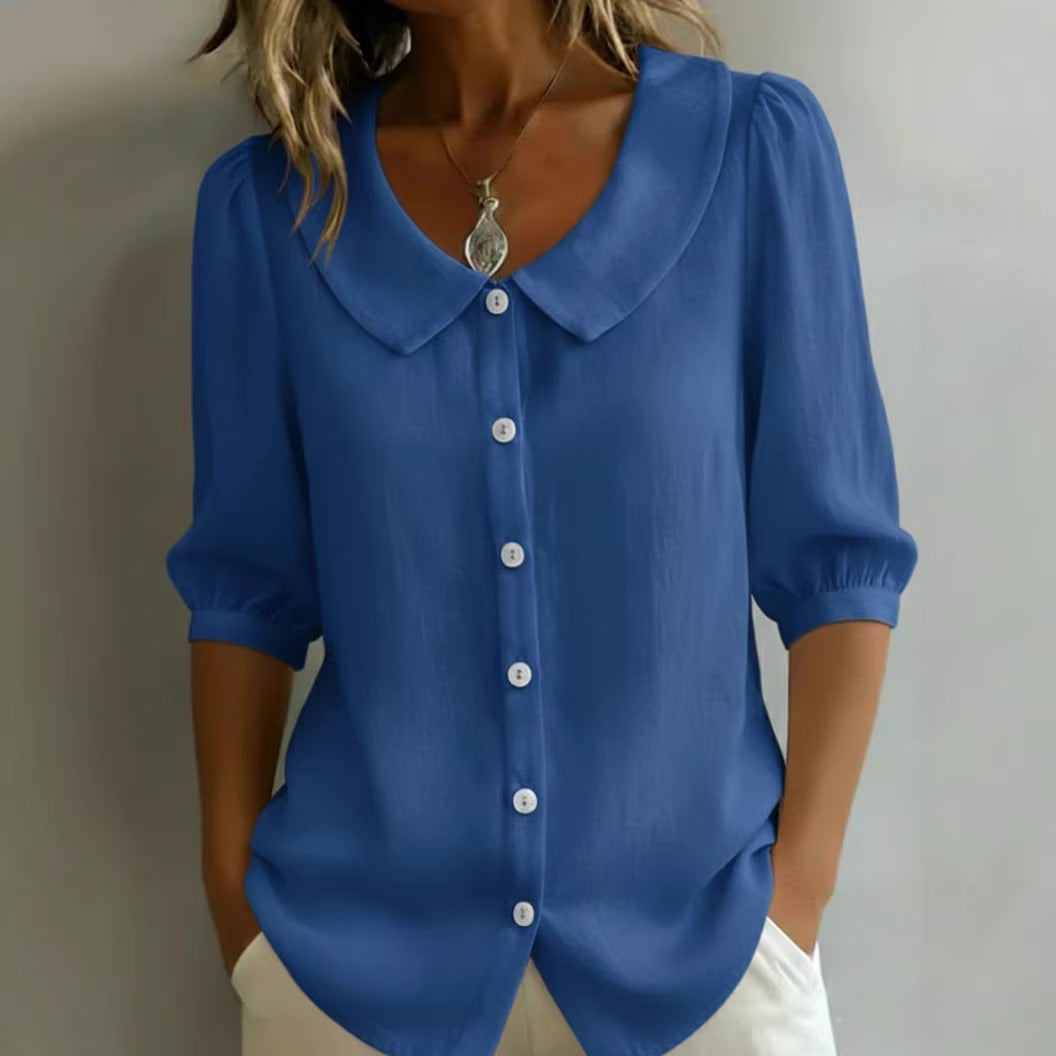 Blue blouse with a collar worn by a person against a neutral background