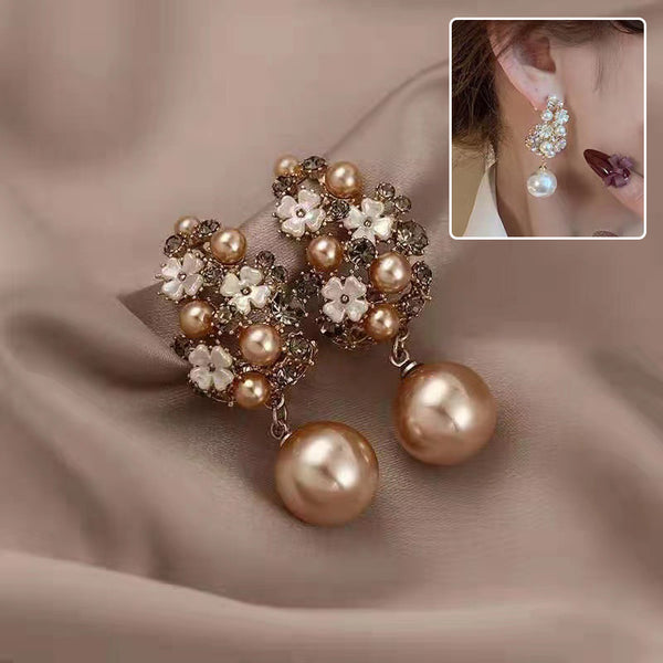 Pearl and flower earrings on a soft fabric background