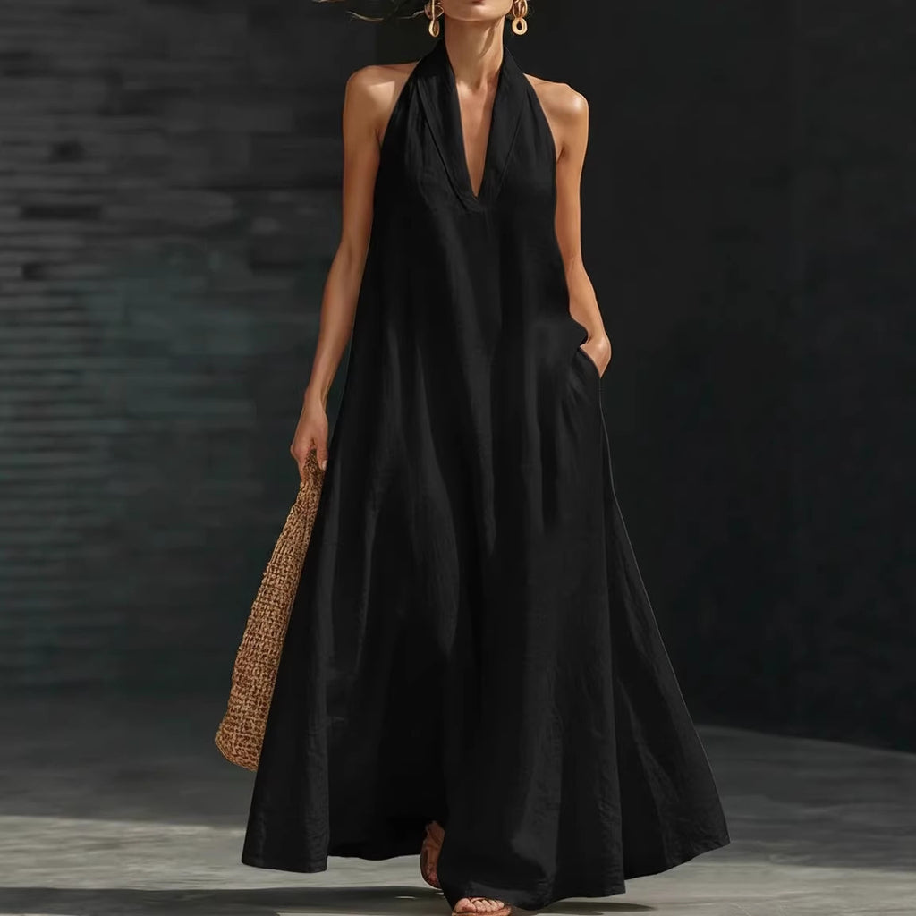 Woman wearing a black sleeveless dress holding a woven bag against a dark background