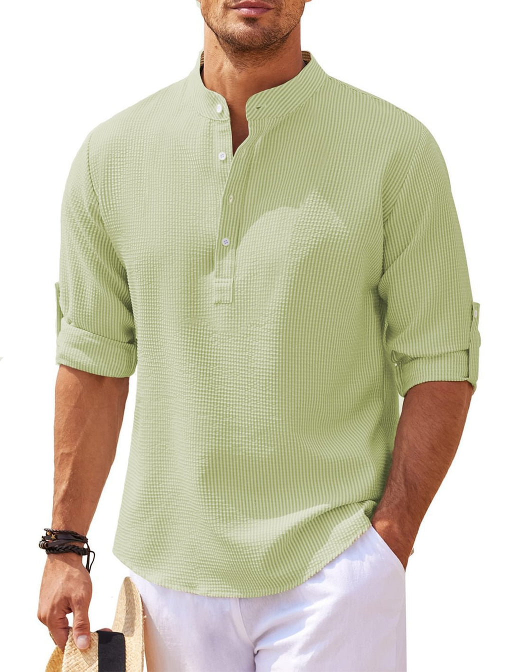 Man wearing a light green textured shirt with rolled-up sleeves on a white background