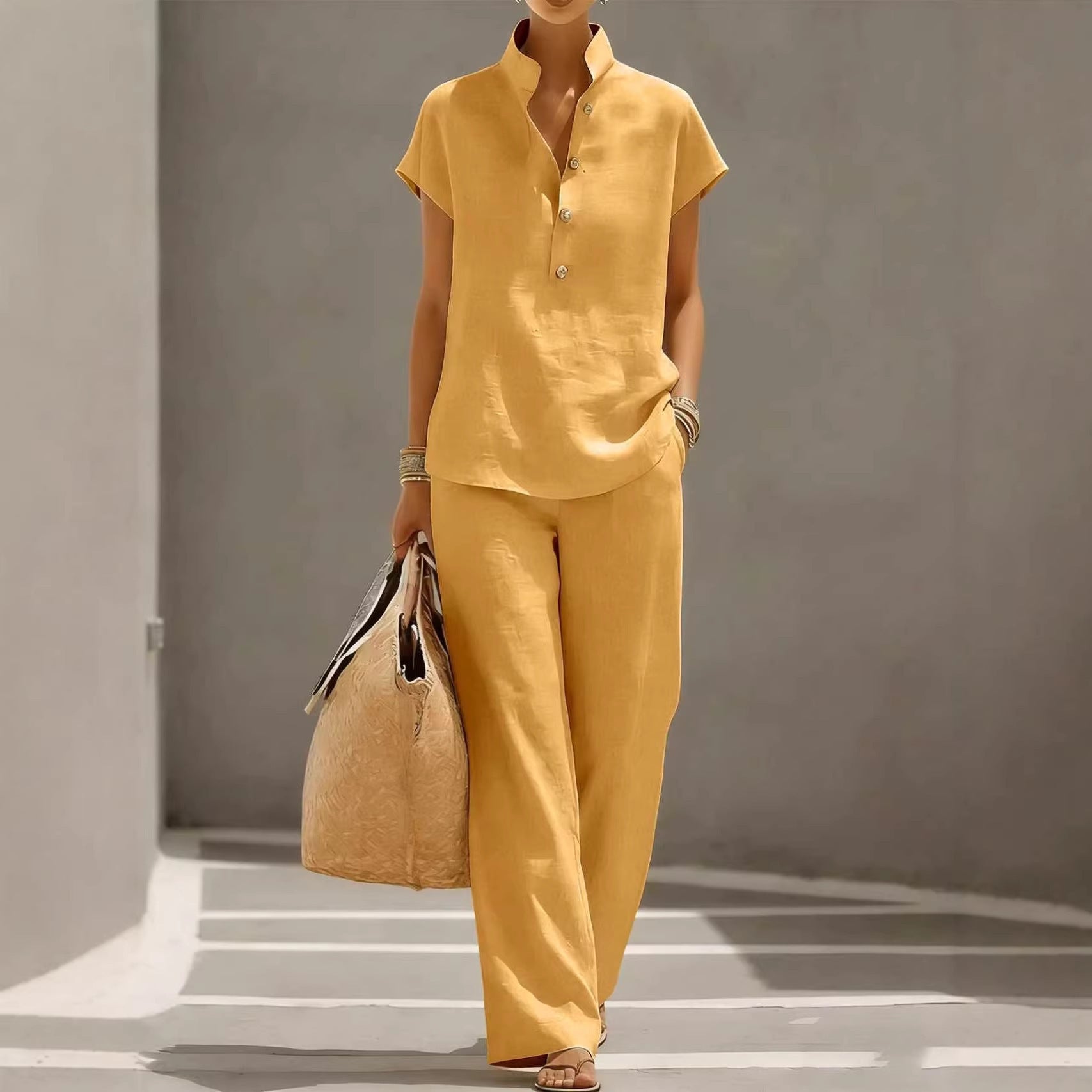 Person wearing a yellow outfit holding a bag against a gray background