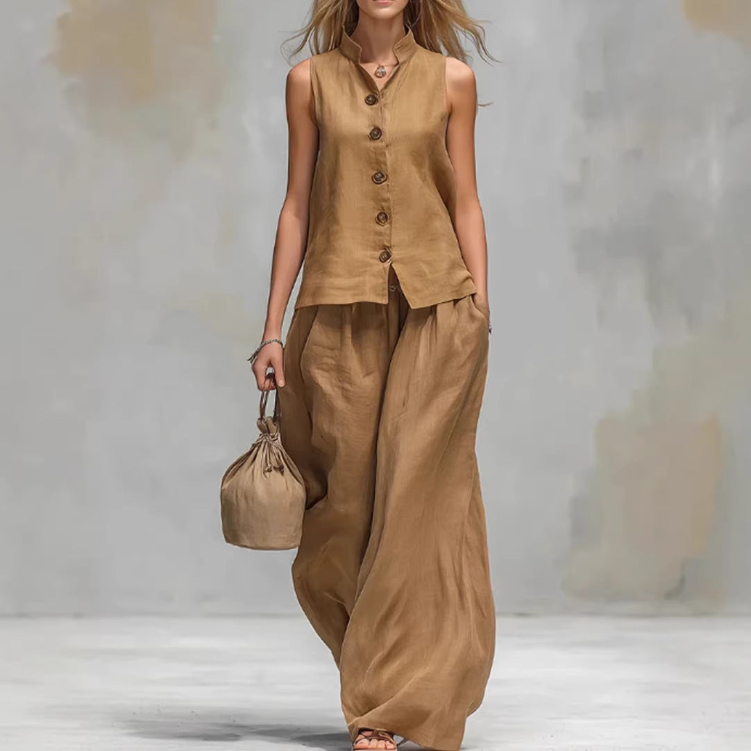 Woman wearing a brown sleeveless top and wide-leg pants holding a matching handbag on a plain background